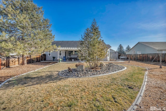 back of property with a lawn and a patio