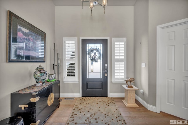 foyer with light hardwood / wood-style flooring and a chandelier