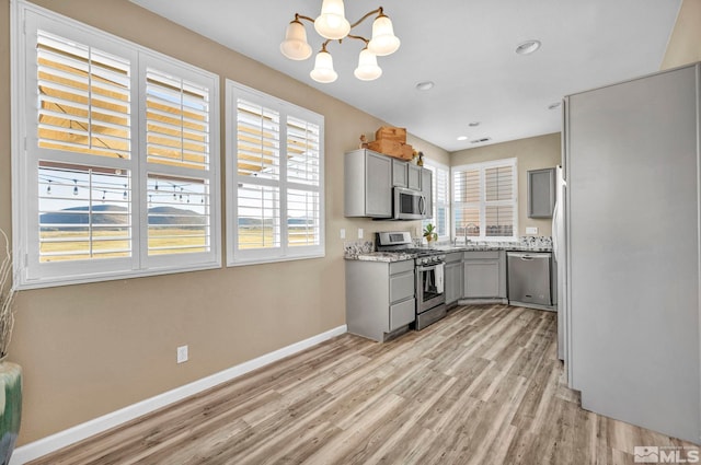 kitchen featuring appliances with stainless steel finishes, light hardwood / wood-style flooring, and a healthy amount of sunlight