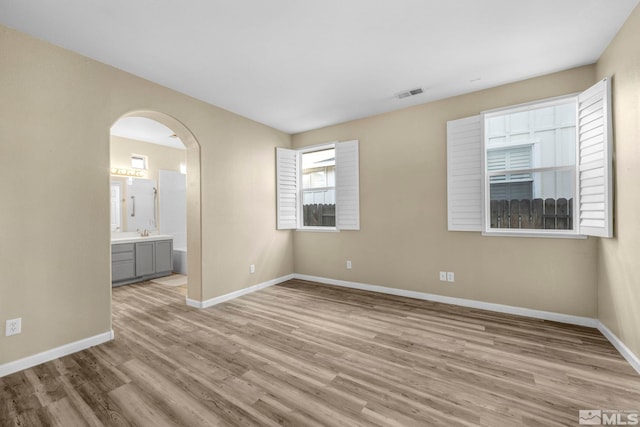 unfurnished room featuring sink and light hardwood / wood-style flooring