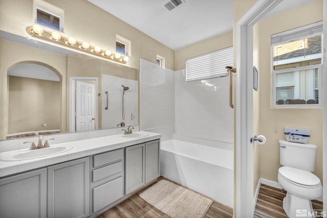 full bathroom with hardwood / wood-style floors, vanity, shower with separate bathtub, and toilet