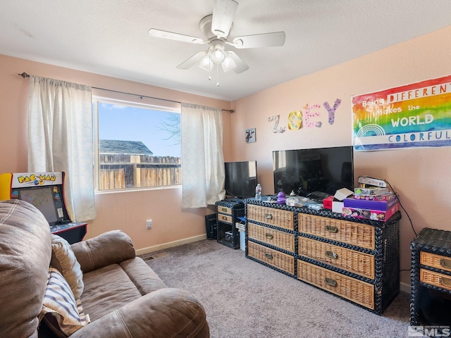 living room featuring carpet flooring, ceiling fan, and a textured ceiling