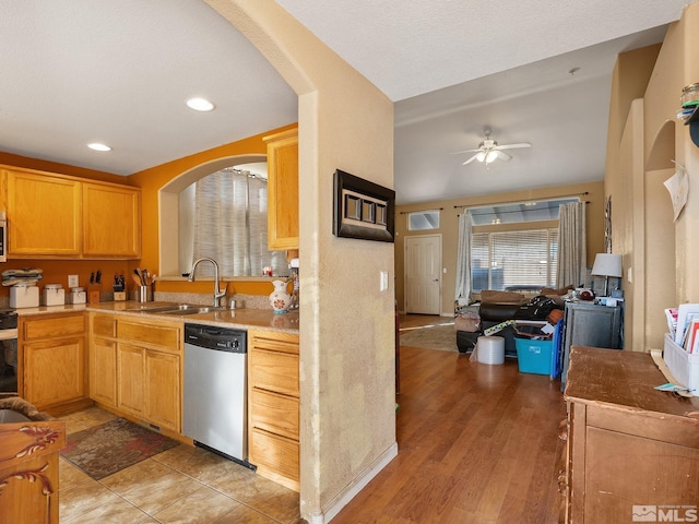 kitchen featuring sink, light hardwood / wood-style flooring, ceiling fan, a textured ceiling, and stainless steel appliances