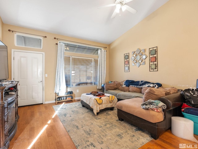 living room featuring ceiling fan, light hardwood / wood-style flooring, and vaulted ceiling