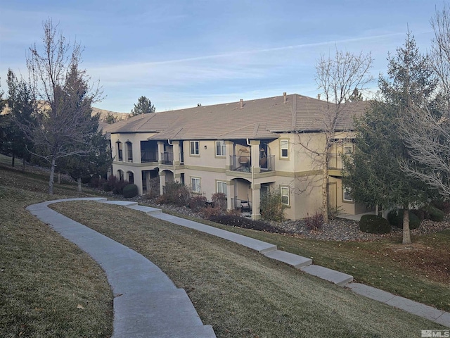 view of front of property with a front yard and a balcony