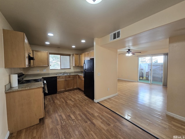 kitchen featuring dark hardwood / wood-style floors, plenty of natural light, and black appliances