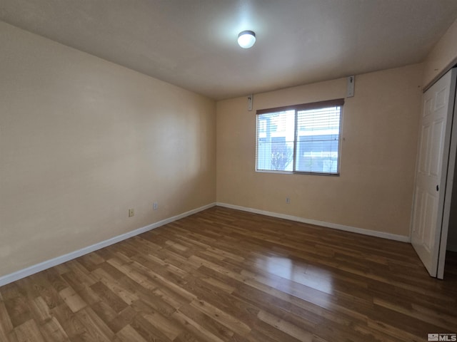 unfurnished bedroom with a closet and dark wood-type flooring