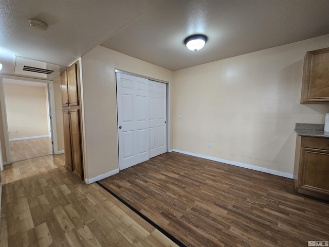 unfurnished bedroom featuring a closet and dark hardwood / wood-style flooring