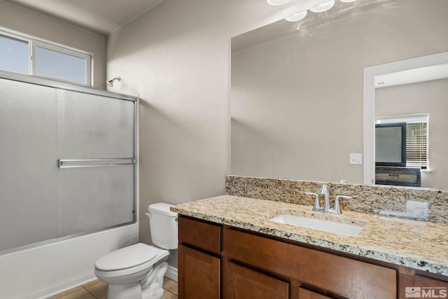 full bathroom featuring tile patterned flooring, vanity, enclosed tub / shower combo, and toilet