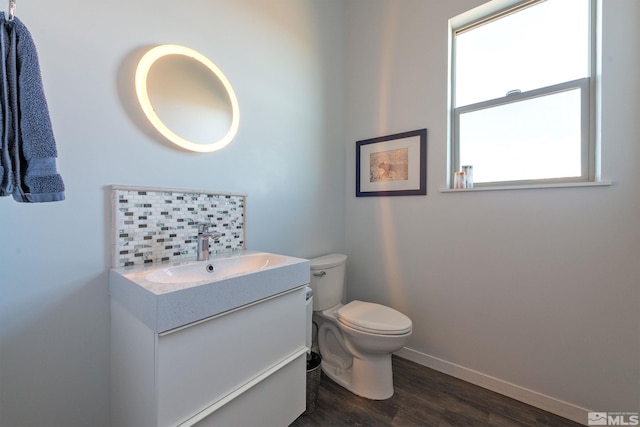 bathroom with hardwood / wood-style floors, vanity, toilet, and backsplash