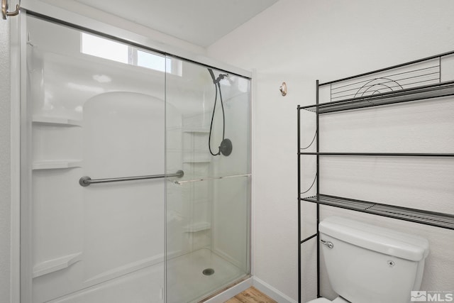 bathroom featuring wood-type flooring, toilet, and walk in shower