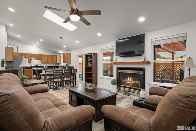 living room featuring ceiling fan, sink, and lofted ceiling