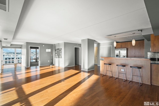 unfurnished living room with dark wood-type flooring