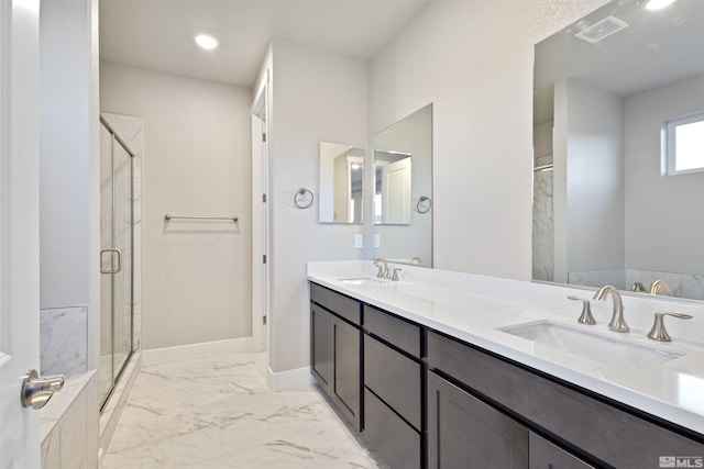 bathroom featuring a shower with door and vanity