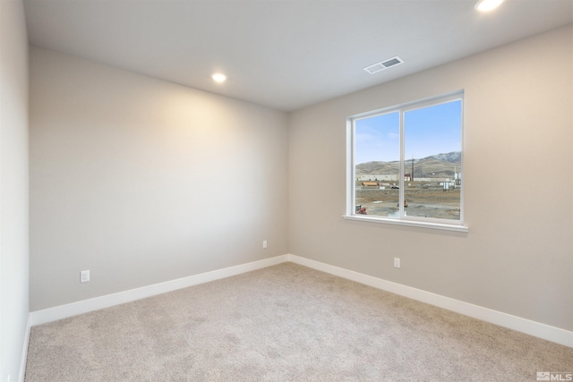 carpeted spare room featuring a mountain view