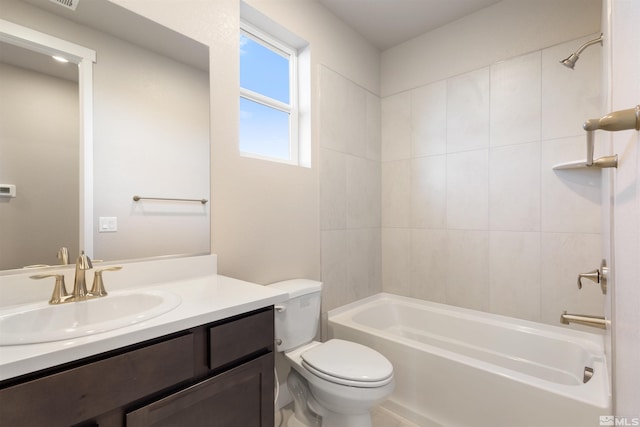 full bathroom featuring vanity, tiled shower / bath combo, and toilet