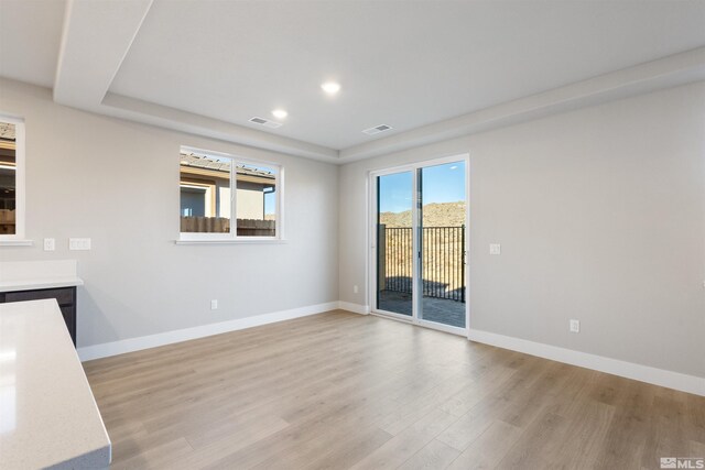 unfurnished room with visible vents, light wood-style flooring, and baseboards