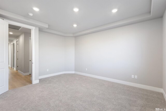 spare room featuring light colored carpet, recessed lighting, and visible vents