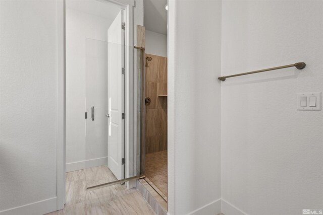 bathroom with a stall shower and baseboards