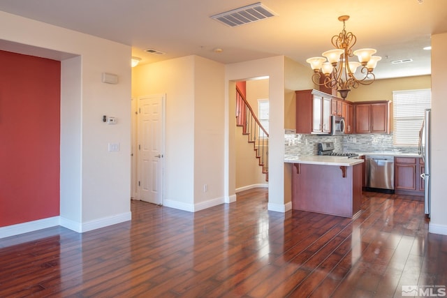 kitchen featuring kitchen peninsula, decorative backsplash, dark hardwood / wood-style flooring, and stainless steel appliances