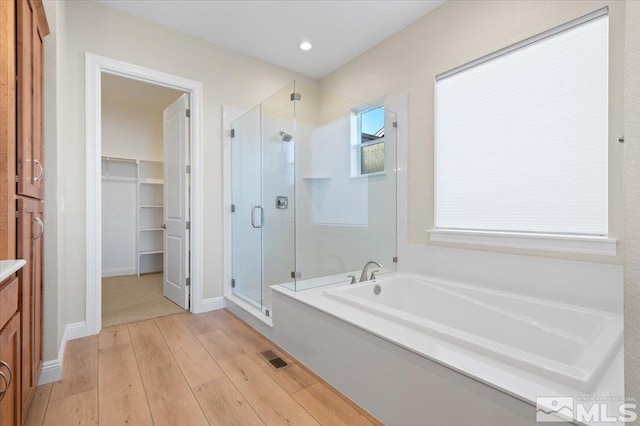 bathroom featuring hardwood / wood-style floors, vanity, and shower with separate bathtub