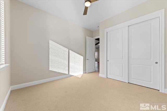 unfurnished bedroom with light carpet, a closet, and ceiling fan