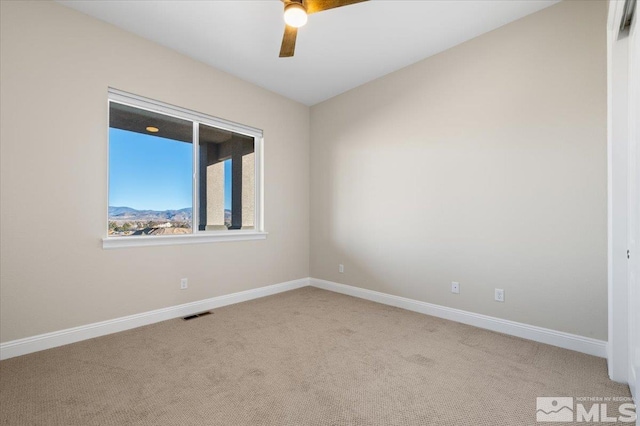 unfurnished room with ceiling fan and light carpet