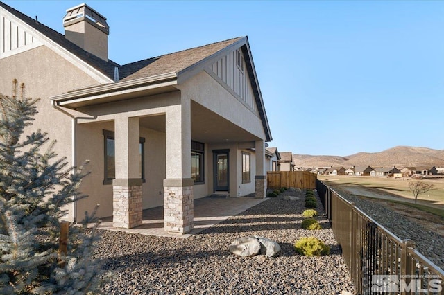 view of side of home featuring a mountain view and a patio