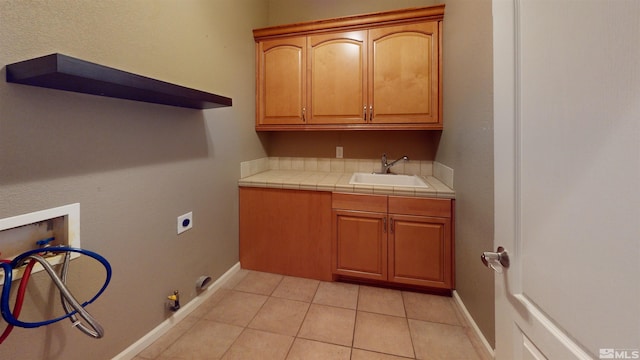 laundry area with cabinets, washer hookup, sink, hookup for a gas dryer, and light tile patterned flooring