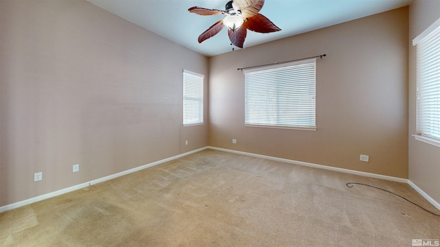 empty room featuring light colored carpet, plenty of natural light, and ceiling fan