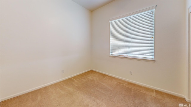 unfurnished room featuring light carpet