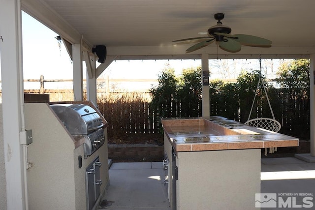 view of patio / terrace with an outdoor kitchen, ceiling fan, and grilling area