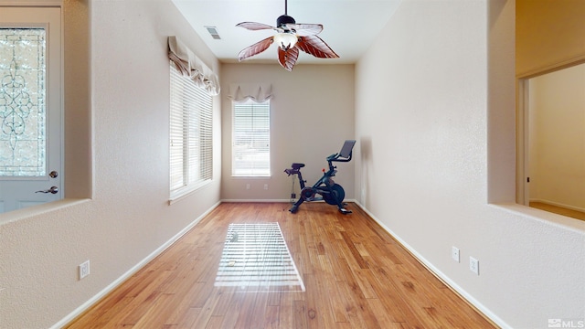 exercise room with ceiling fan and light hardwood / wood-style floors