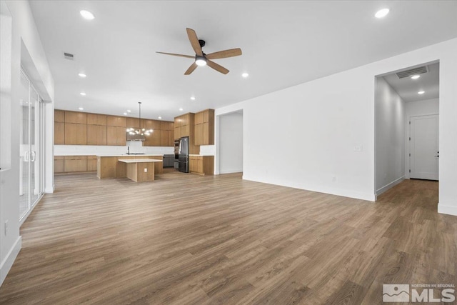 unfurnished living room with hardwood / wood-style floors and ceiling fan