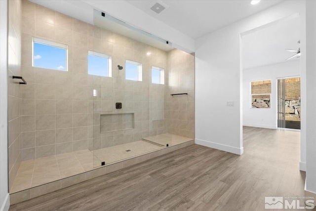 bathroom with a tile shower, ceiling fan, and hardwood / wood-style flooring