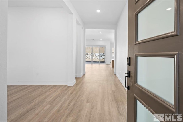 corridor with light hardwood / wood-style floors