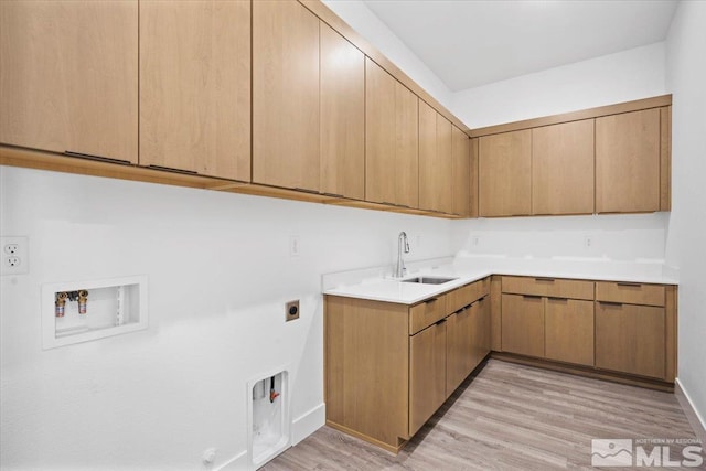 laundry room with sink, washer hookup, cabinets, electric dryer hookup, and light wood-type flooring