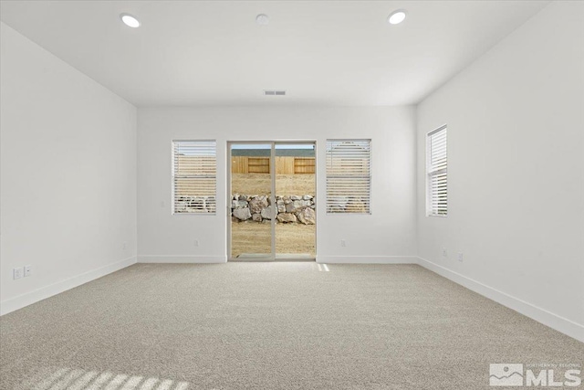 empty room featuring light colored carpet and plenty of natural light