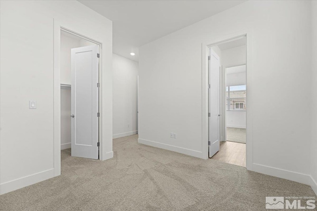 interior space featuring a walk in closet and light carpet