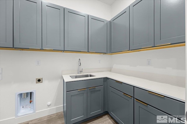 washroom with sink, cabinets, electric dryer hookup, hookup for a gas dryer, and light wood-type flooring