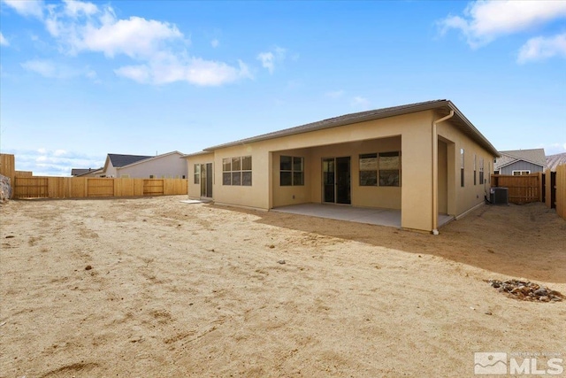 back of property with a patio and central AC