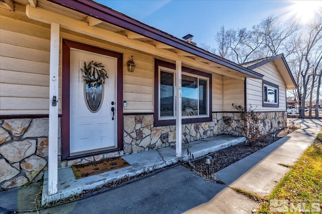 view of exterior entry featuring covered porch