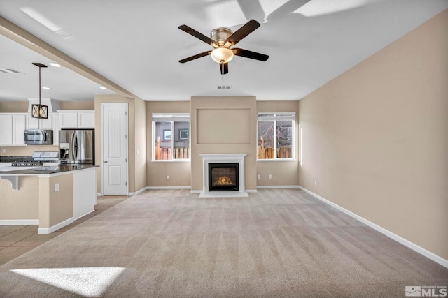 unfurnished living room featuring ceiling fan and light carpet