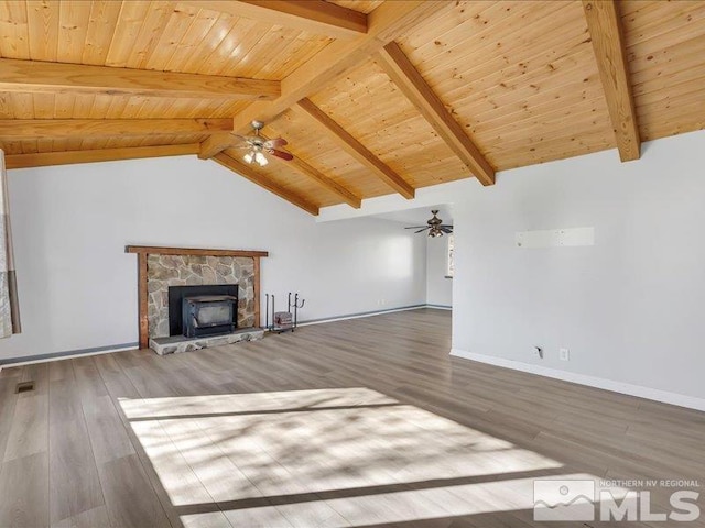 unfurnished living room with vaulted ceiling with beams, ceiling fan, a stone fireplace, and wood-type flooring