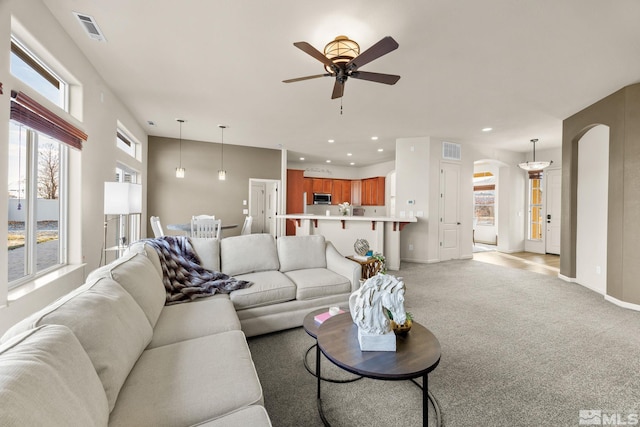 living room featuring light carpet, a wealth of natural light, and ceiling fan