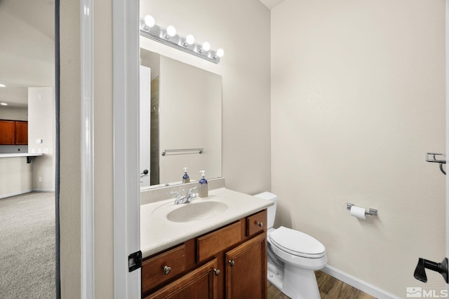 bathroom featuring hardwood / wood-style flooring, vanity, and toilet