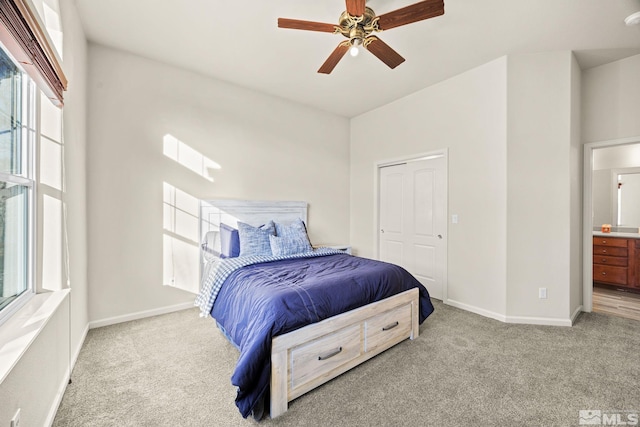 carpeted bedroom with ceiling fan, a closet, and ensuite bath