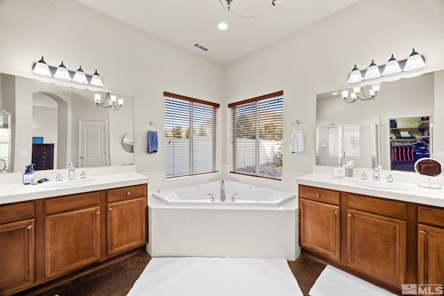 bathroom featuring vanity, an inviting chandelier, and separate shower and tub