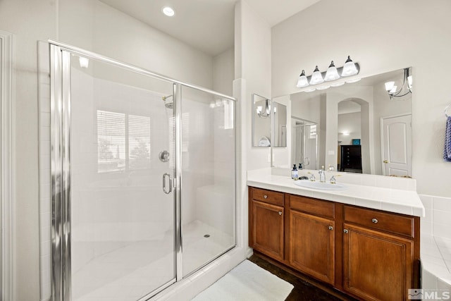 bathroom featuring a shower with door, vanity, and an inviting chandelier