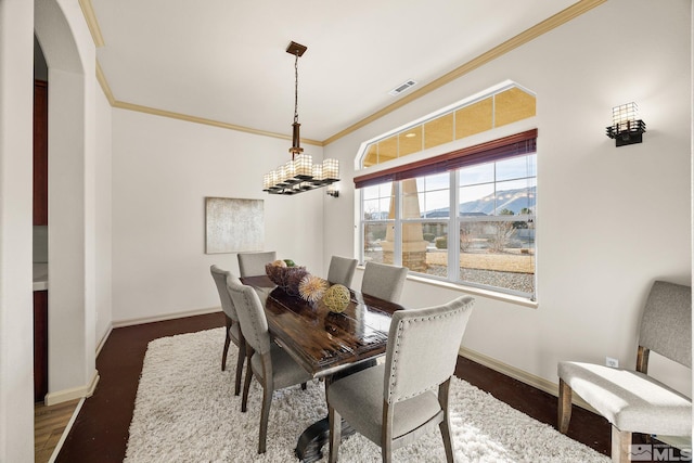 dining area with a mountain view, dark hardwood / wood-style flooring, and ornamental molding